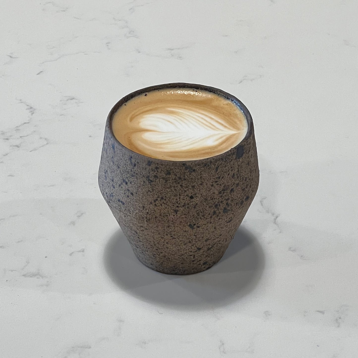 Angular tea cup filled with cappuccino